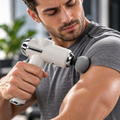 Mini pistola massaggiante percussiva bianca con testina tonda grigia