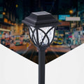 Lampada LED da giardino con paralume in vetro e struttura nera, su palo.