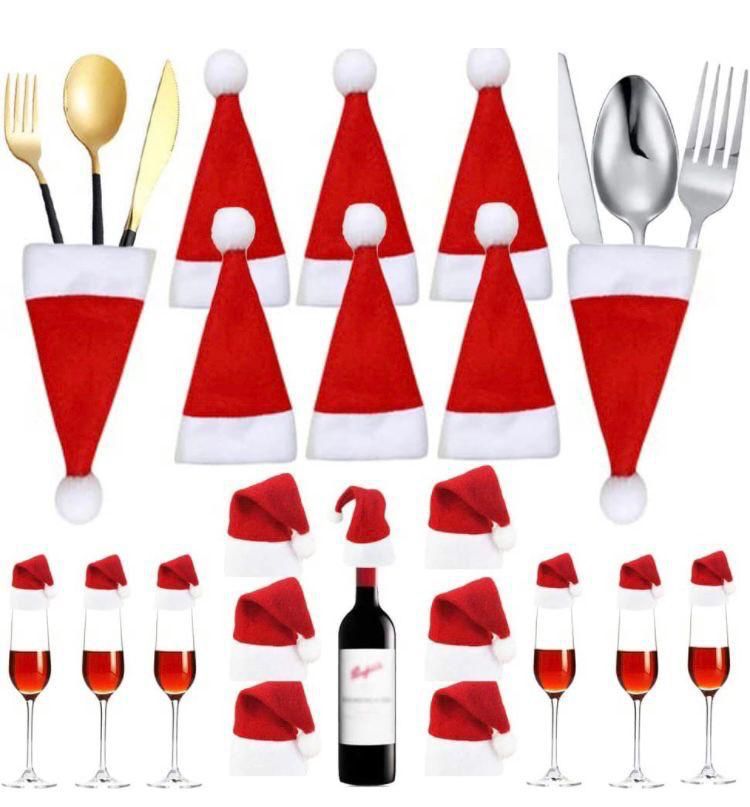 Kit da tavola con mini cappelli rossi Babbo Natale: bordo bianco e pon pon, su posate e bottiglia.