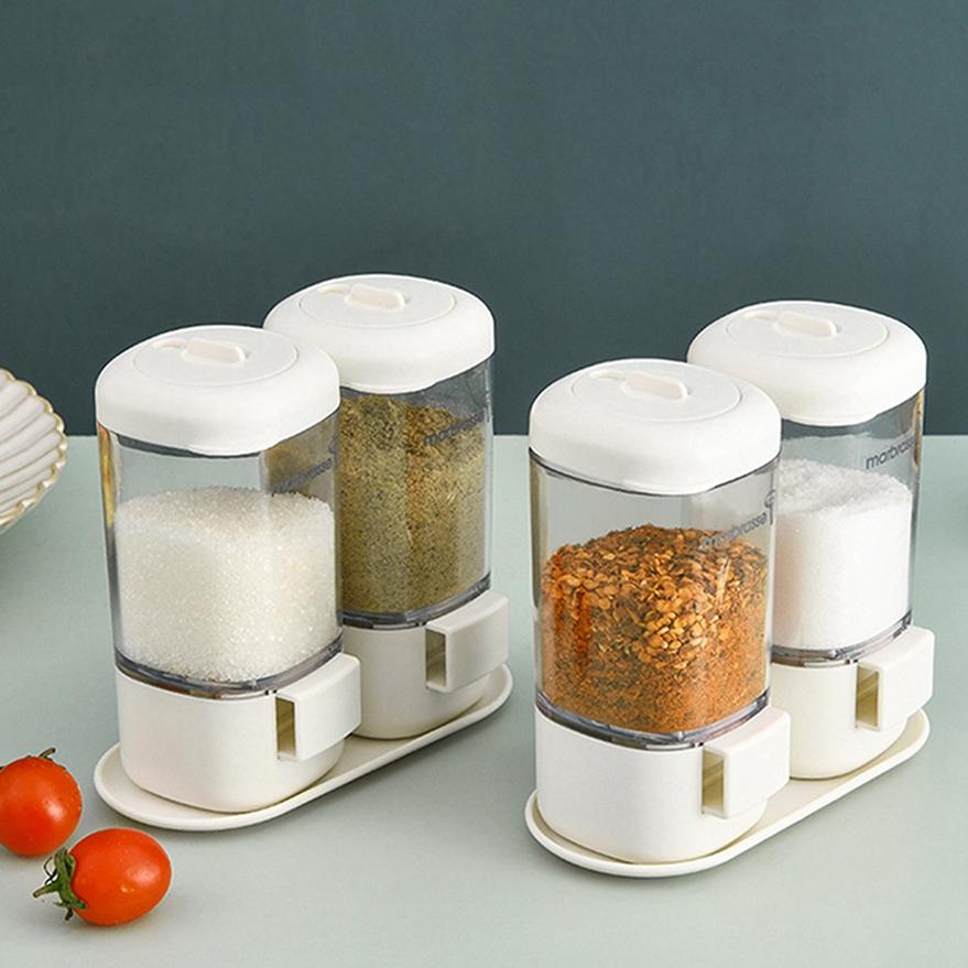 Set di 2 dosatori per spezie con barattoli trasparenti e coperchi bianchi su base