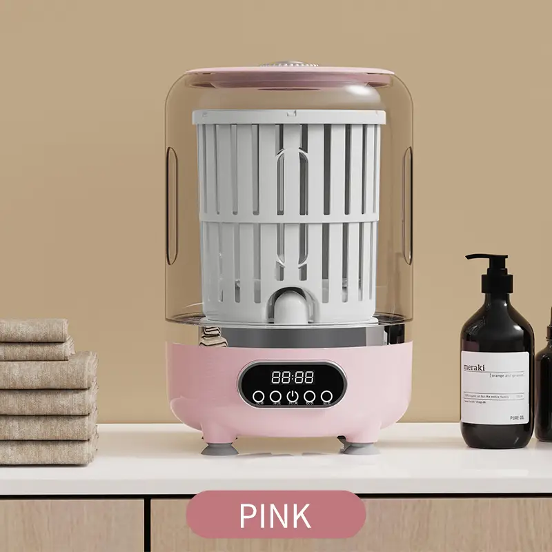 Mini lavatrice portatile 3-in-1 rosa con comandi frontali e oblò trasparente.