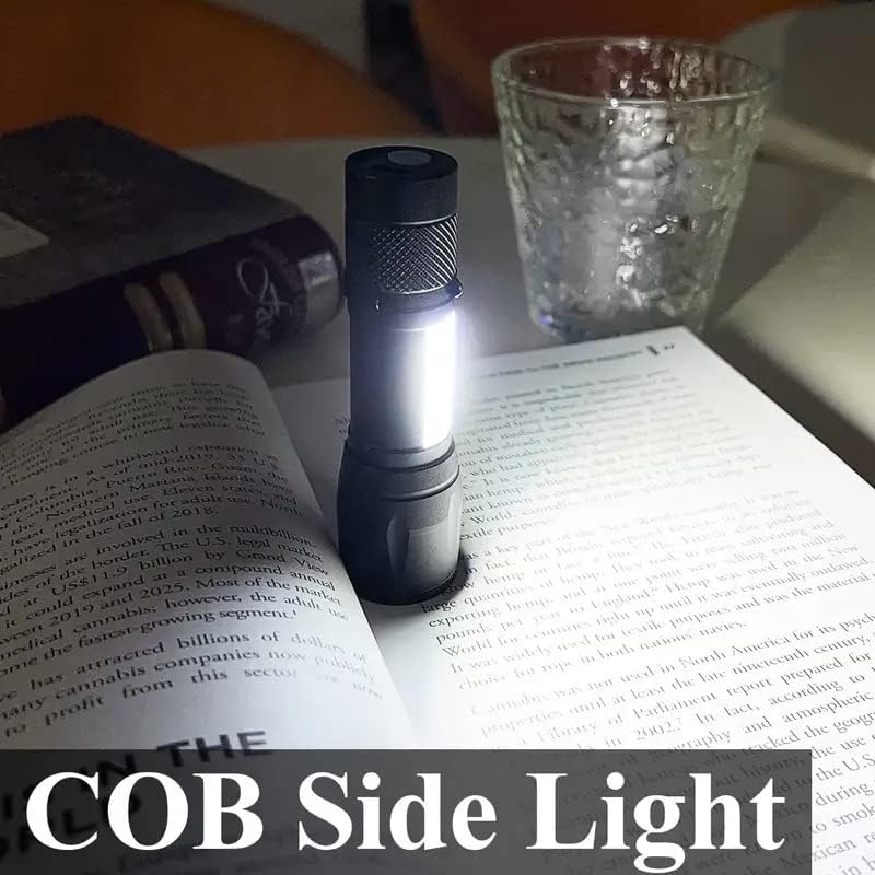 Torcia LED nera con luce bianca su libro aperto