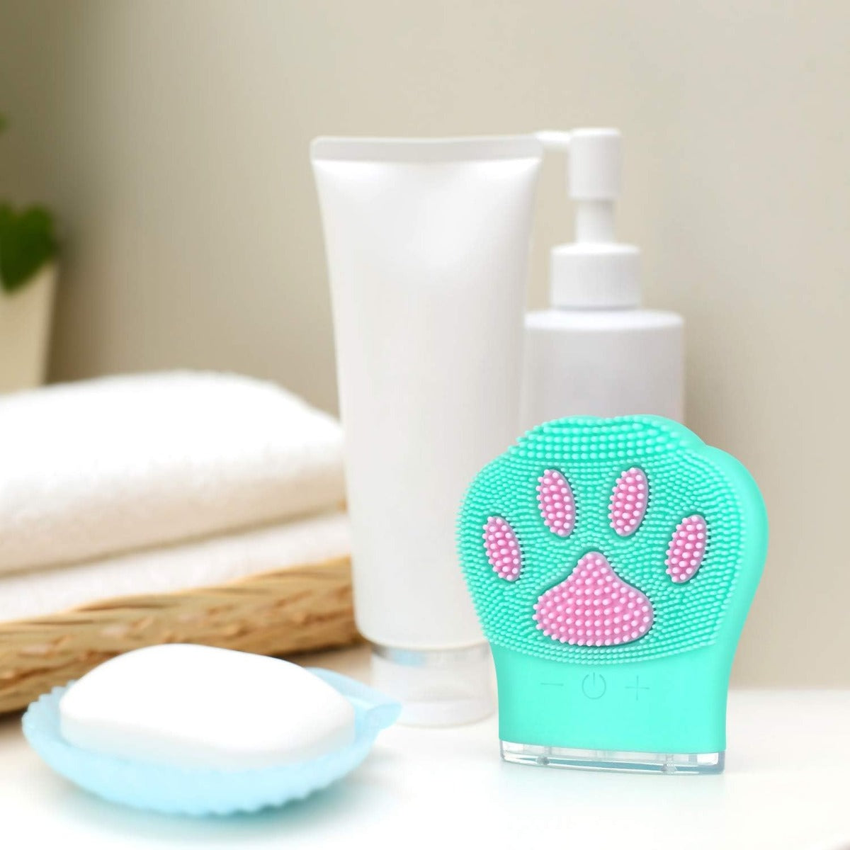 Spazzola detergente viso in silicone azzurro con testina a zampa e pulsanti sul manico