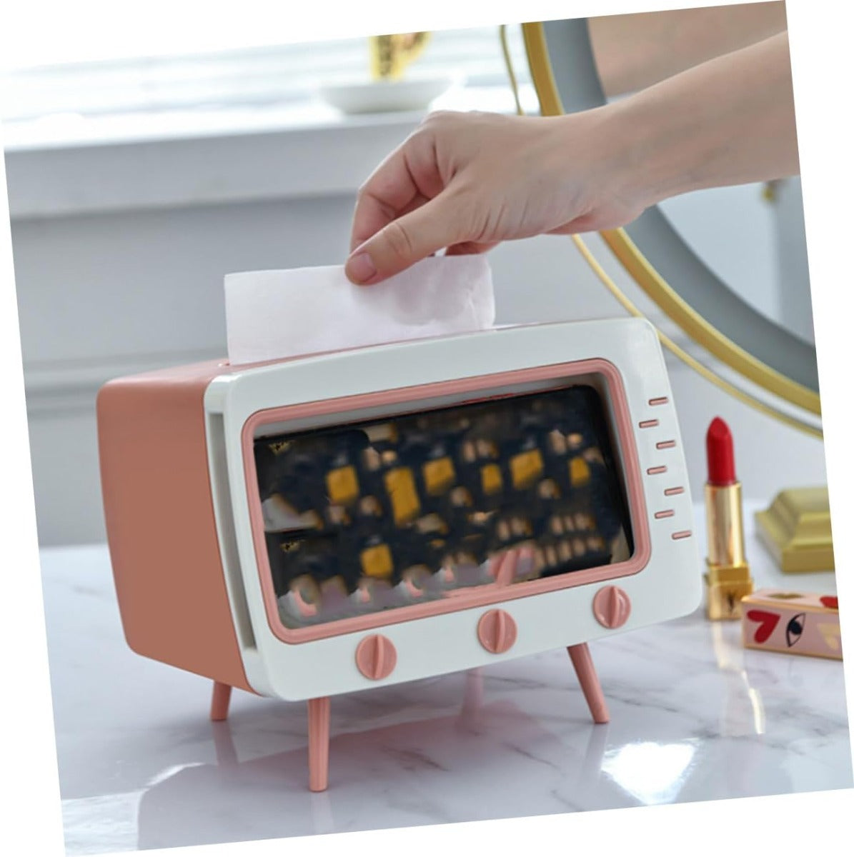 Porta fazzoletti a forma di TV bianco e rosa, mano inserisce un fazzoletto superiore