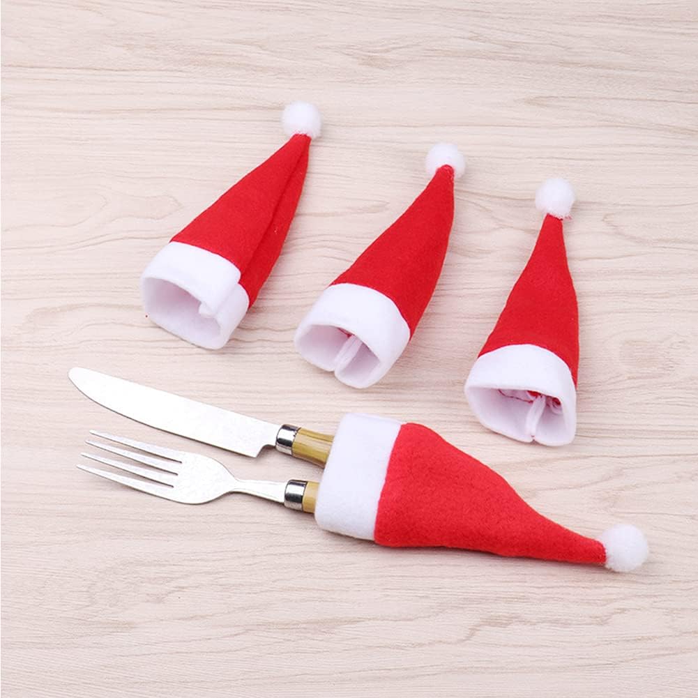 Mini cappelli di Babbo Natale rossi con bordo bianco e pon-pon, su piano chiaro