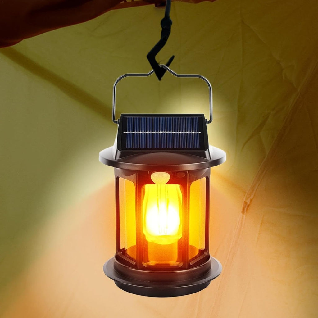 Lanterna solare nera accesa con vetro arancione e pannello solare superiore, luce LED