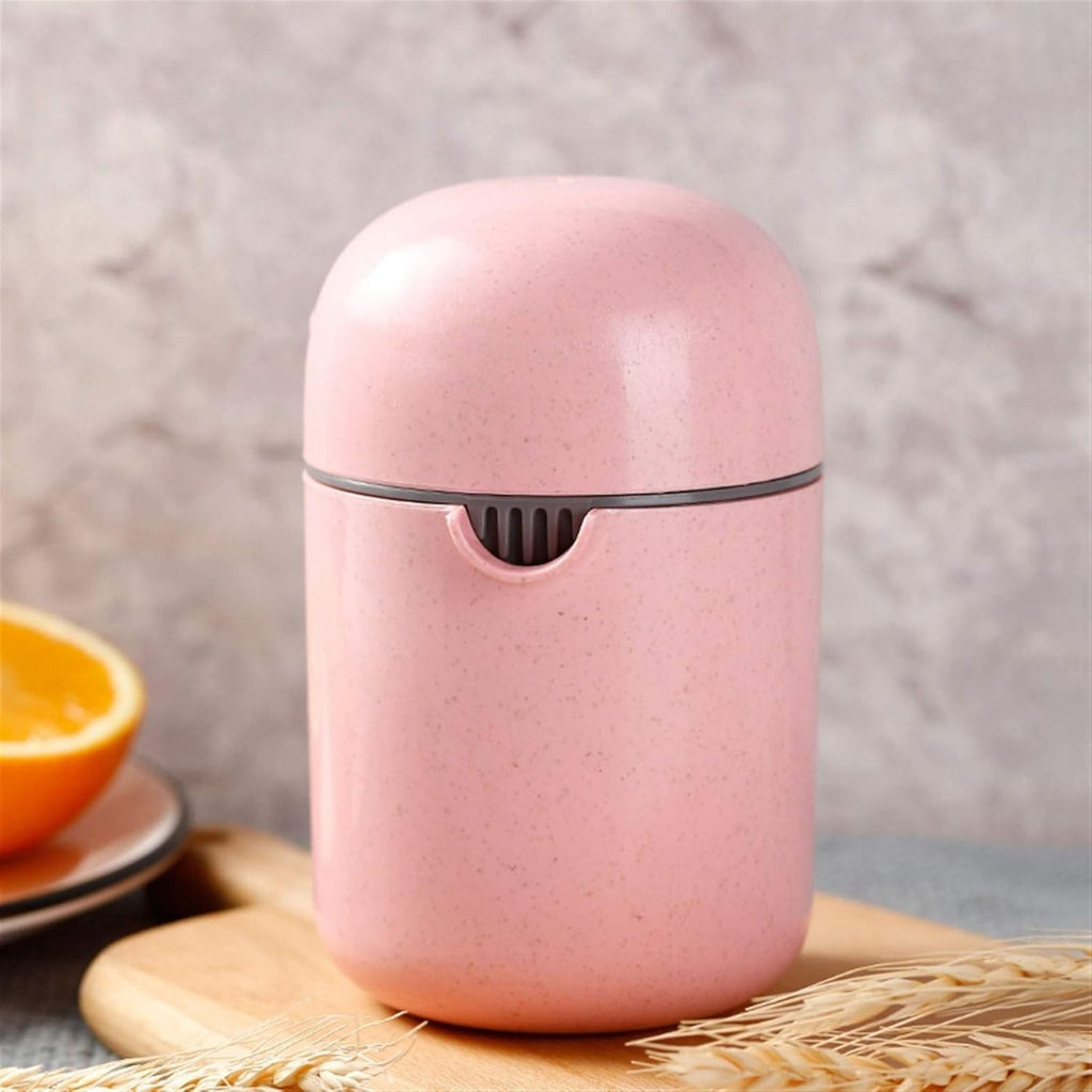 Spremiagrumi manuale portatile rosa con filtro forato, su piano