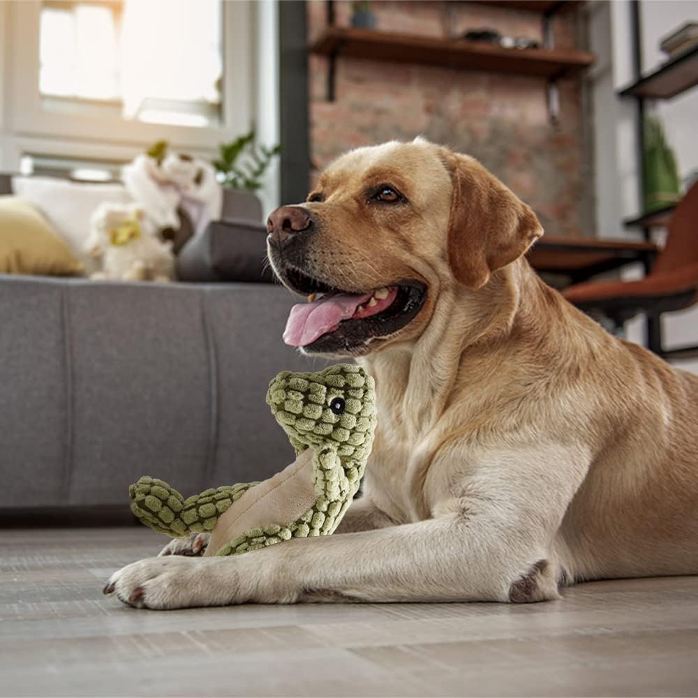 Peluche dinosauro verde oliva con squeaker, tenuto dal cane