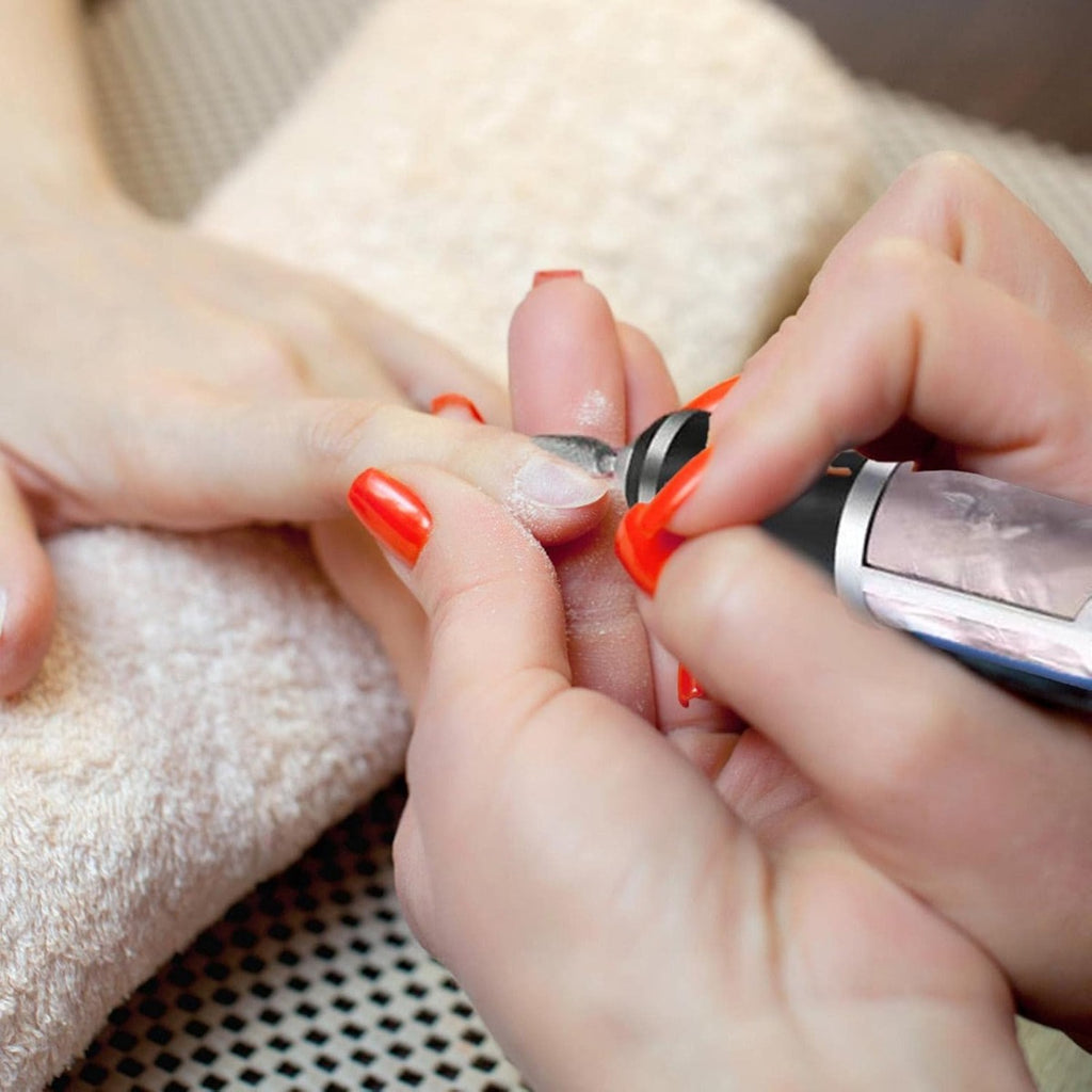 Lima elettrica per unghie cordless mentre affina unghie rosse