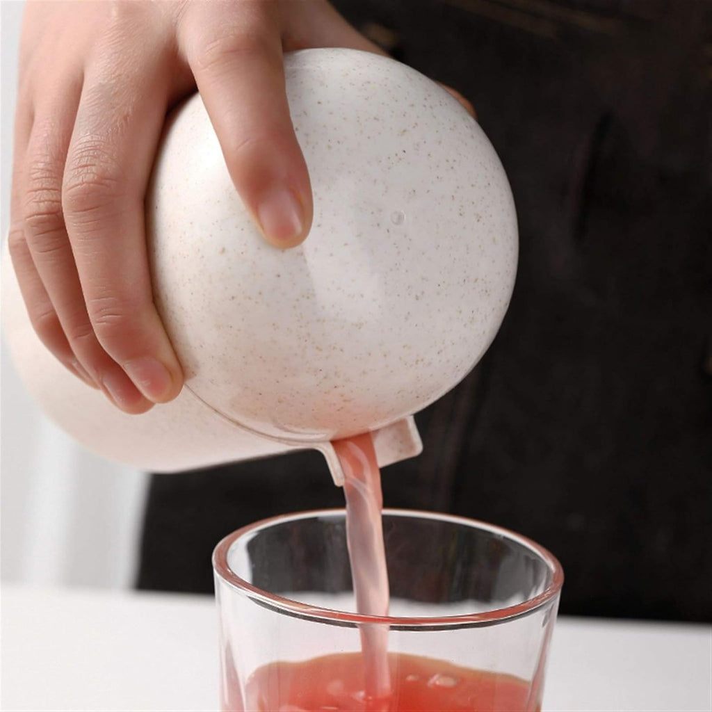 Spremiagrumi manuale bianco con mano che versa succo in un bicchiere