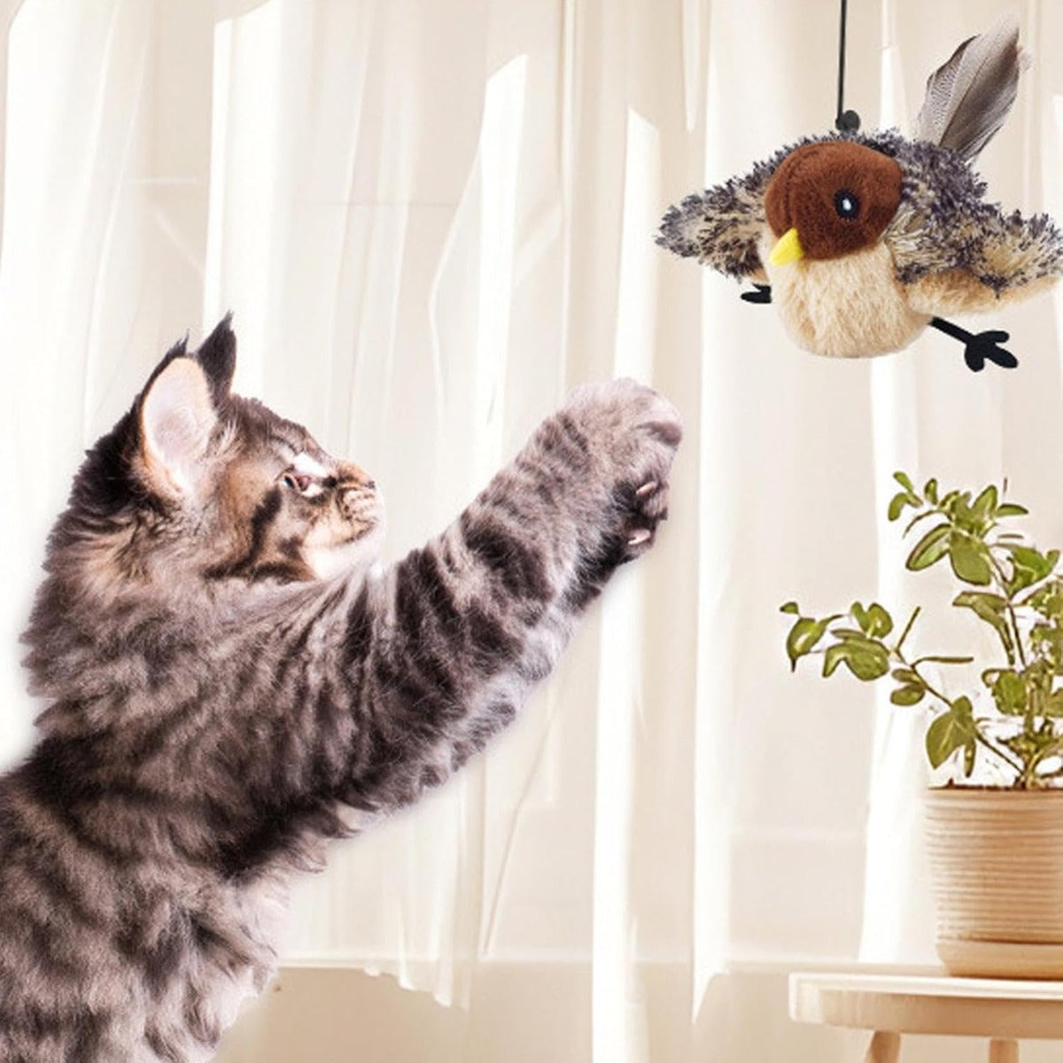 Giocattolo per gatti a forma di uccello in peluche marrone e grigio, appeso vicino al gatto