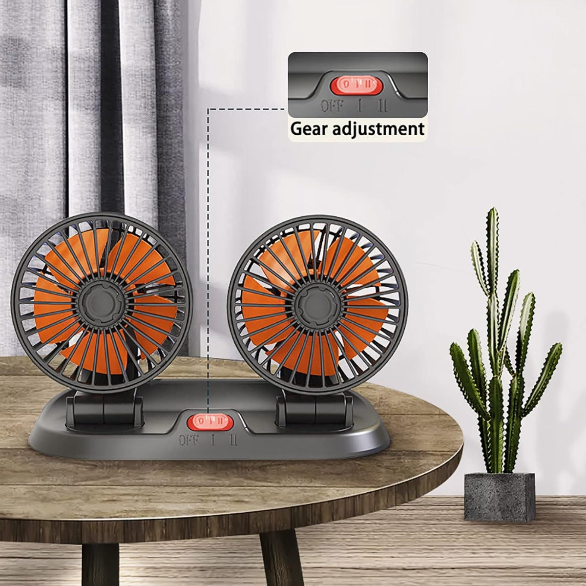 Ventilatore doppio da auto nero con pale arancioni, due teste orientabili e base.