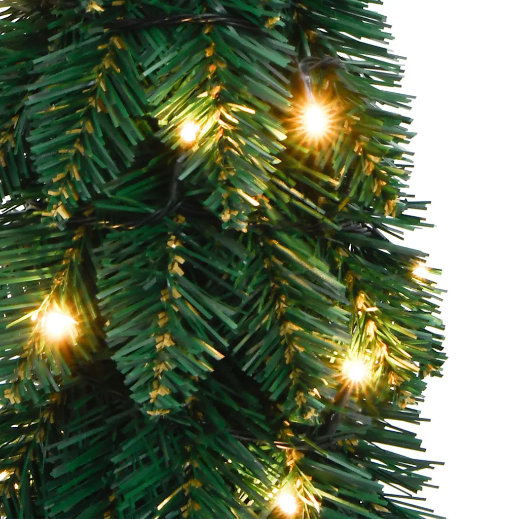 Rami verdi dell’albero di Natale con luci LED calde accese