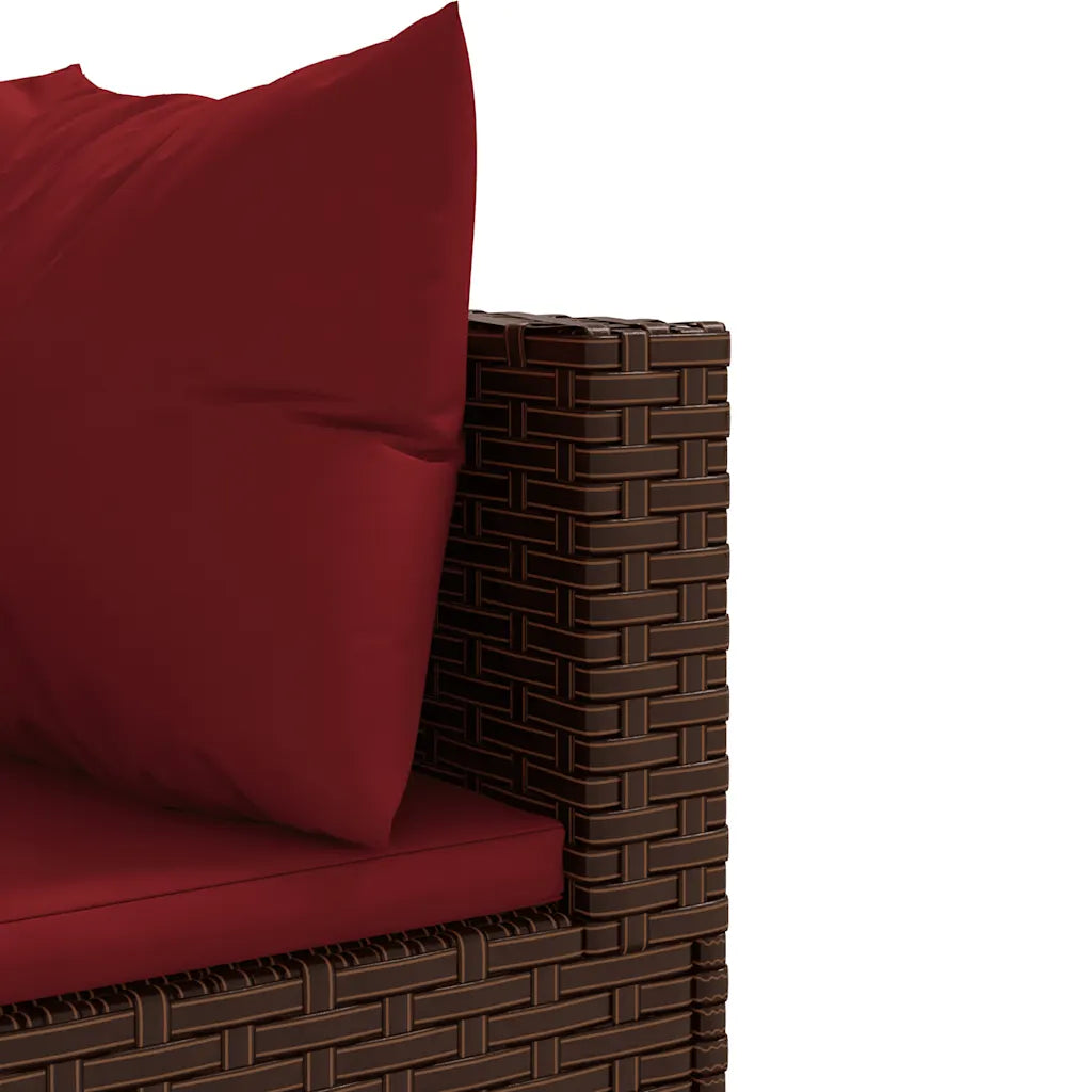 Dettaglio angolo del divano: cuscino rosso su poltrona in polyrattan marrone