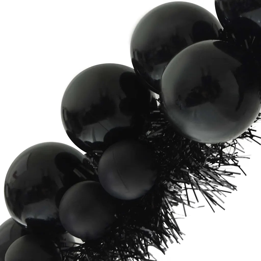 Palline nere lucide e ciuffo di fili sul bordo della ghirlanda