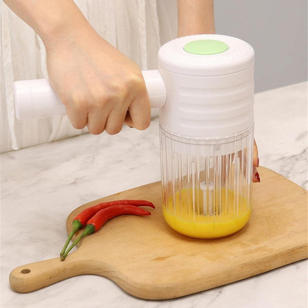 Mixer ricaricabile bianco con contenitore trasparente e mano durante la preparazione