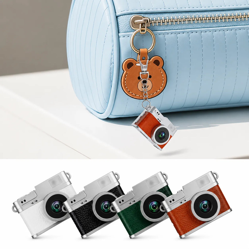 Mini fotocamera portachiavi con custodia marrone e anello, attaccata a borsetta azzurra.