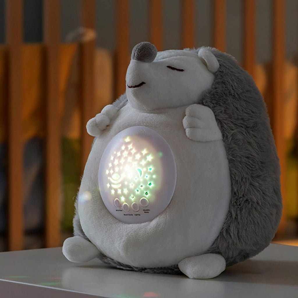 Riccio di peluche bianco e grigio con proiettore acceso sul pancino, luci multicolore