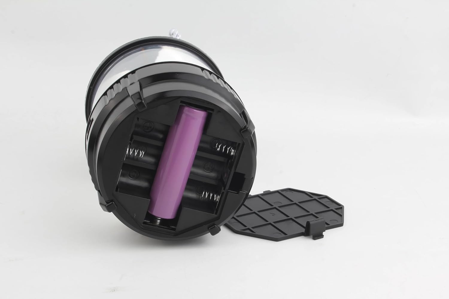 Proiettore LED da palco nero con vano batterie aperto e batteria viola inserita