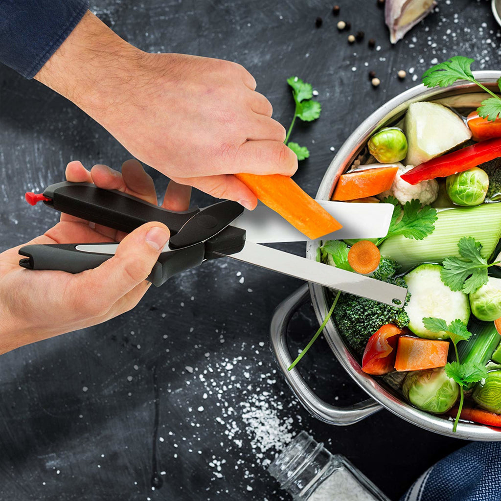 Forbice tagliaverdure ergonomica in uso: lame bianche e manici neri, su verdure