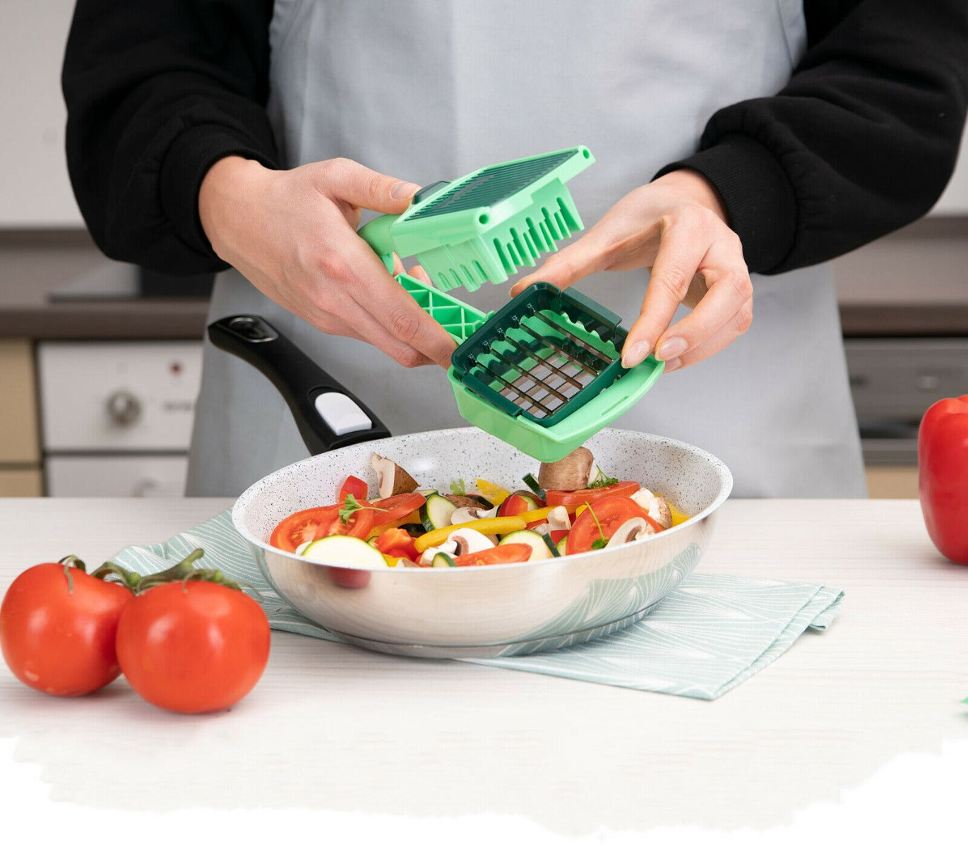 Affettaverdure manuale verde che affetta verdure in una ciotola