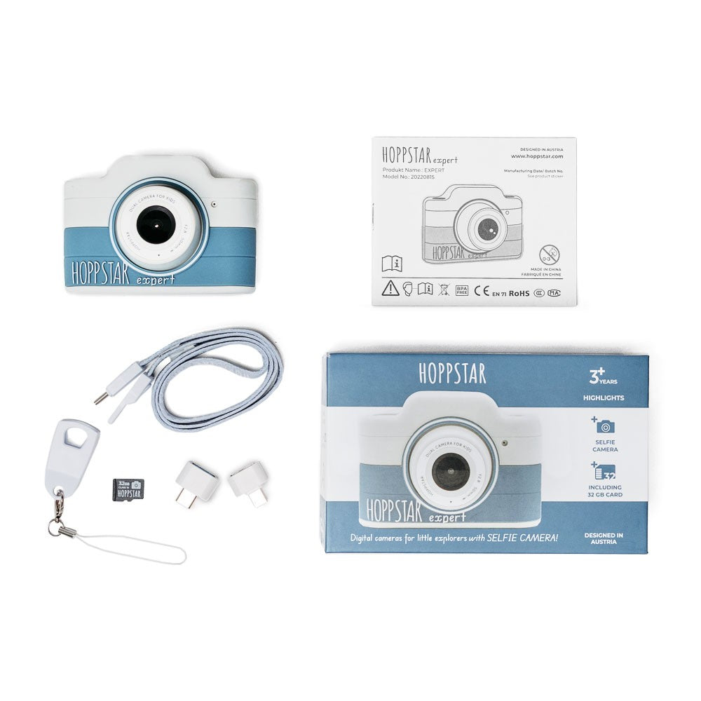 Fotocamera per bambini Hoppstar Expert, confezione con cavo, scheda SD e adattatore.