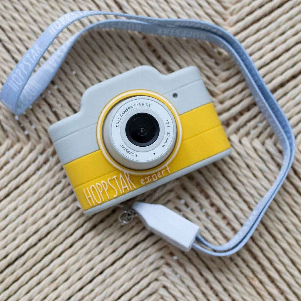 Fotocamera per bambini azzurra e gialla vista dall’alto con cinturino blu