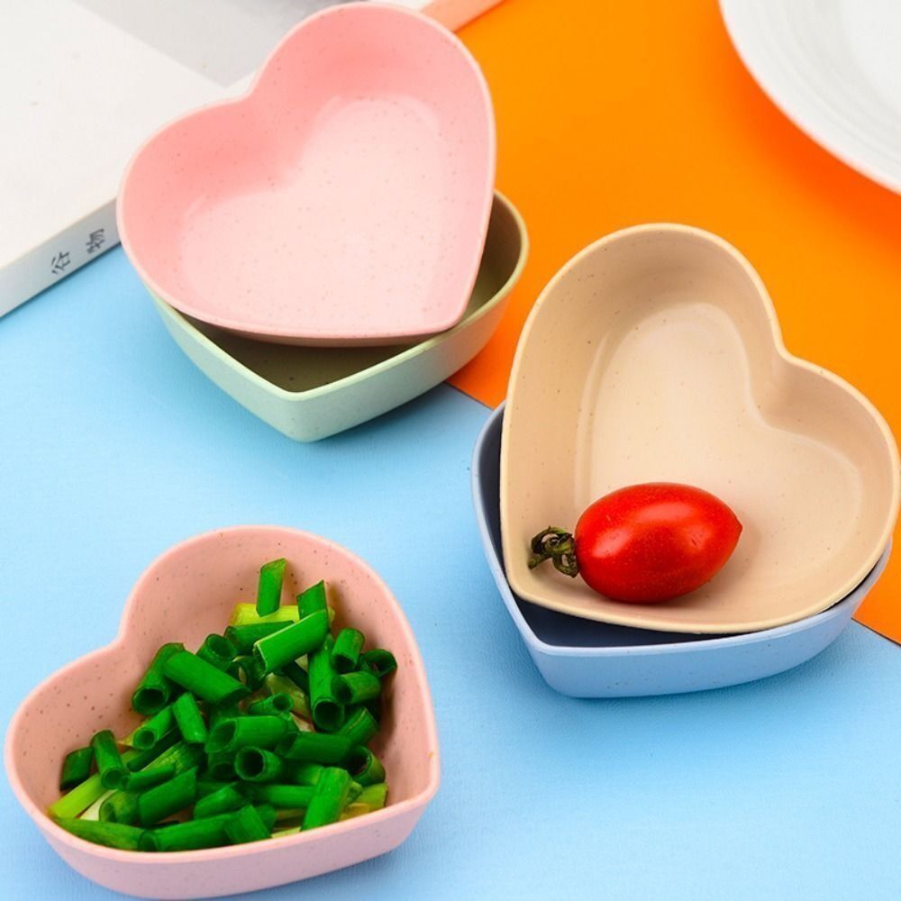Ciotole cuore in plastica rosa e beige con pomodoro e verdure verdi