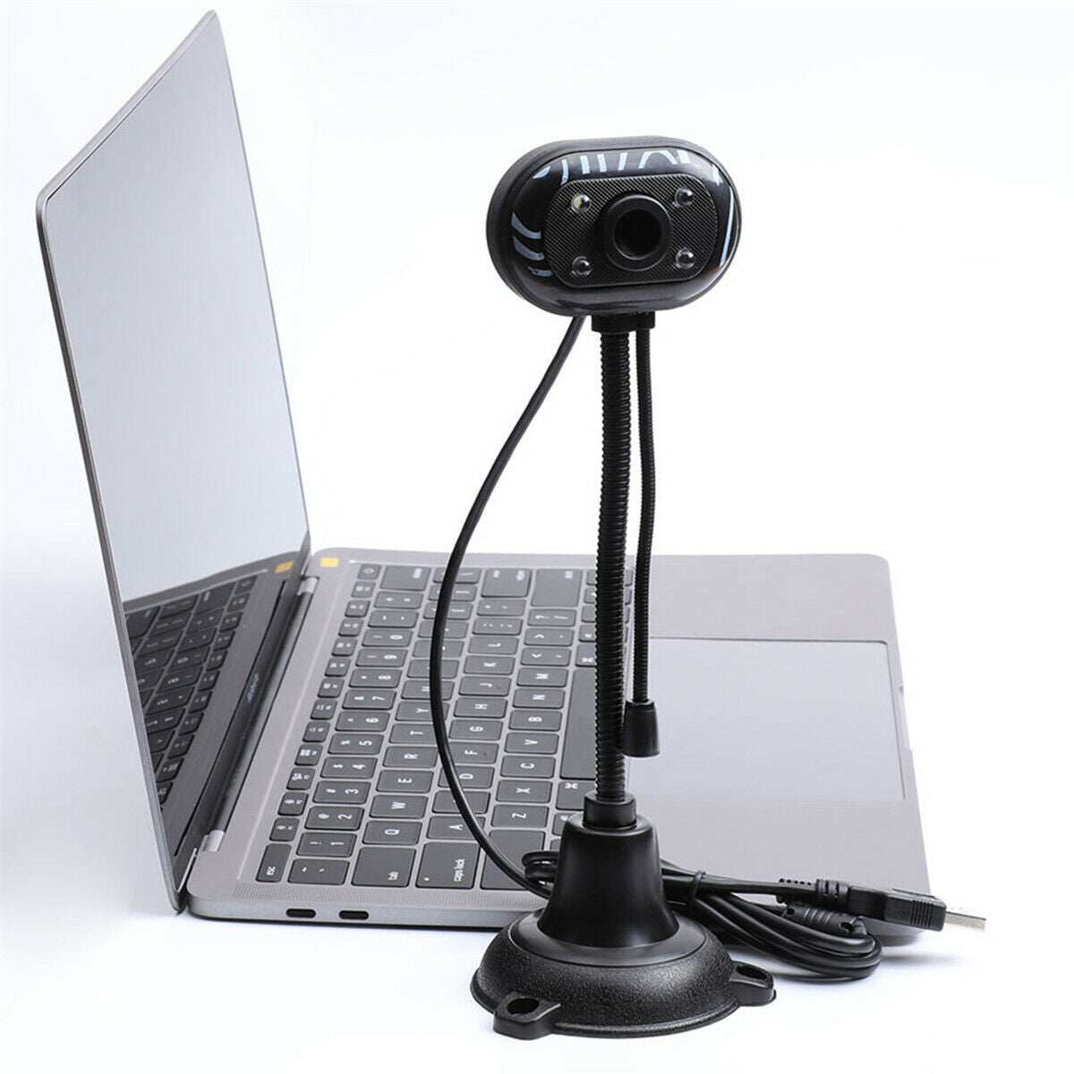 Webcam HD nera con base tonda e cavi, davanti a laptop aperto.