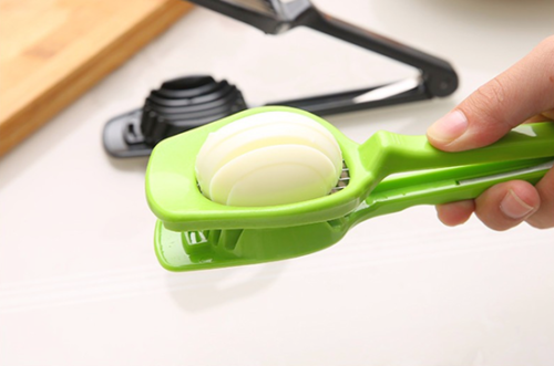 Affetta mozzarella verde in mano, taglia una mezza cipolla con lama a griglia