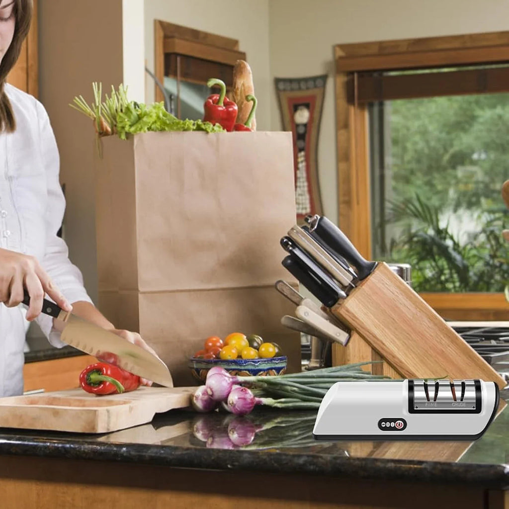 Affilacoltelli elettrico bianco su piano con coltello in metallo