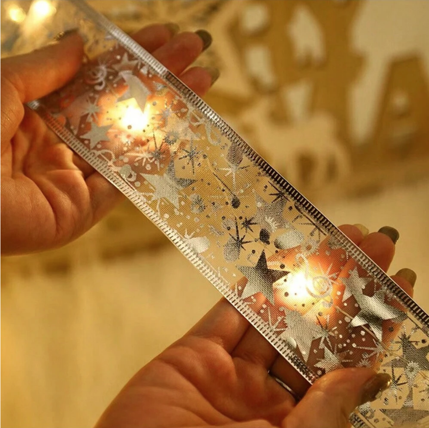 Nastro LED dorato con fantasia natalizia e luci calde, in mano