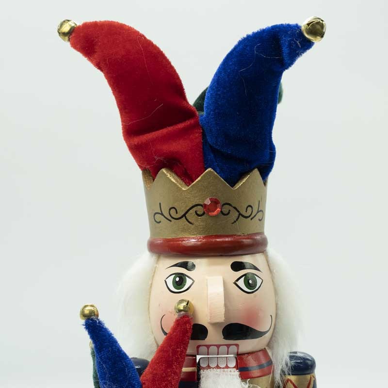 Schiaccianoci natalizio: cappello jolly rosso e blu, dettagli dorati e occhi verdi