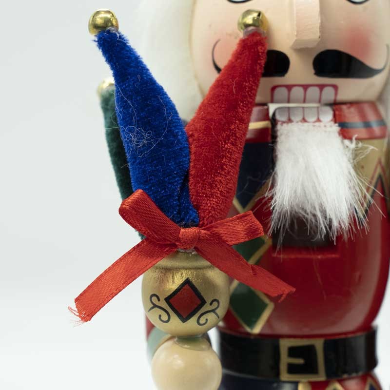 Primo piano di schiaccianoci natalizio: volto bianco, naso nero, cappello blu e rosso