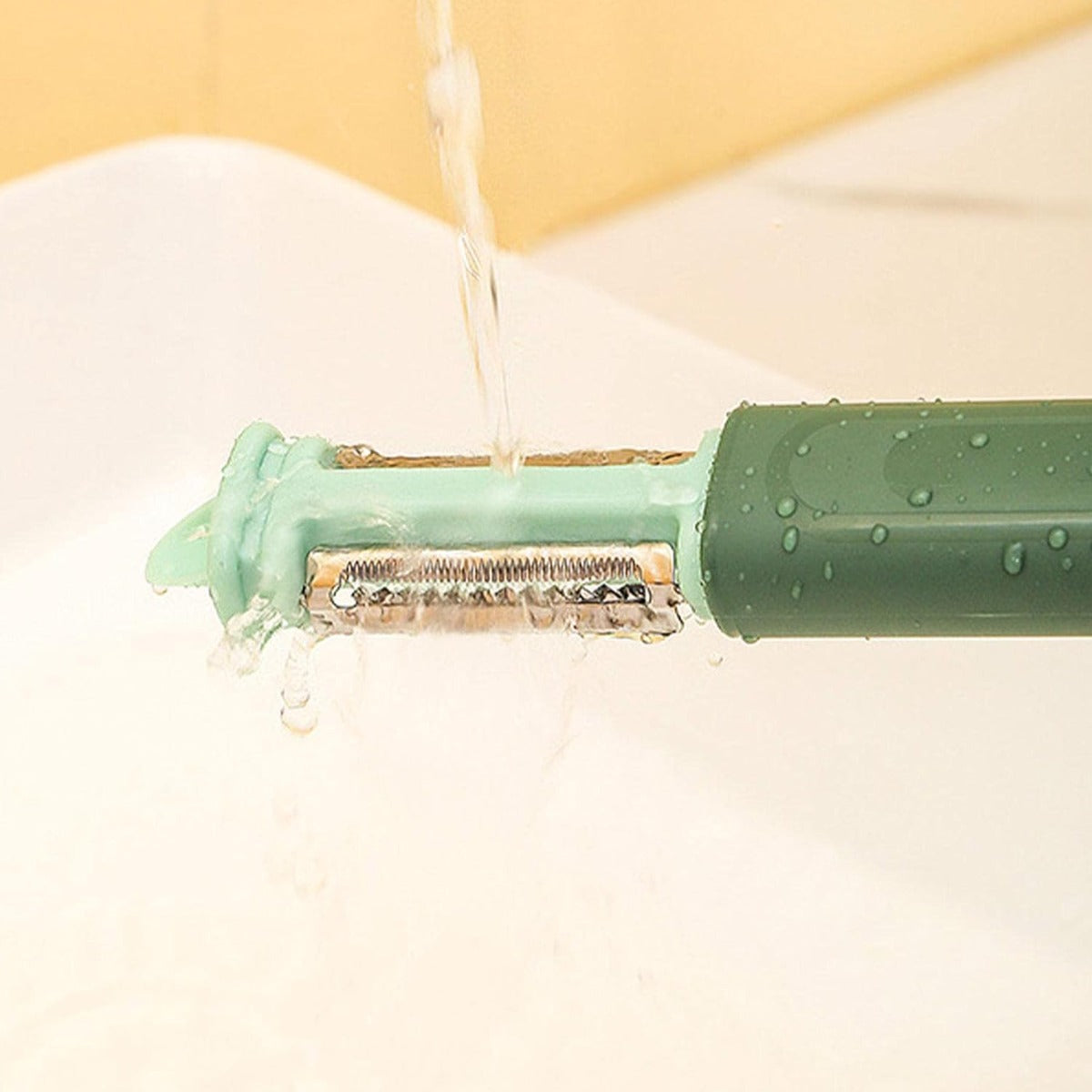 Attrezzo pelaverdure 7-in-1 verde con lama metallica, getto d’acqua per pulizia