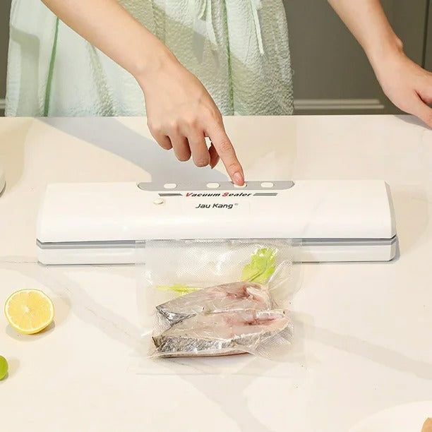 Macchina sottovuoto automatica bianca con coperchio e sacchetti sigillati sotto vuoto